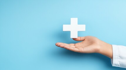 Obraz premium Doctor's hand holds plus sign on light blue background