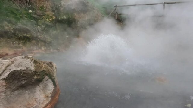 Slow motion eruption of crater water containing sulfur covered in hot steam.Candradimuka Crater, Dieng, Central Java, Indonesia. Geothermal and environmental concepts. 4K Footage