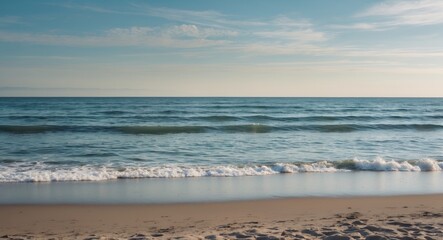 Obraz premium Serene Beach Scene with Gentle Waves and Calm Sea Under a Clear Sky Featuring Empty Space for Text or Overlay