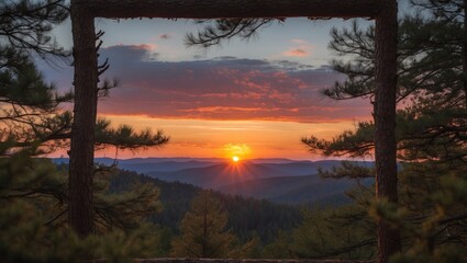 Stunning Sunset Framed by Pine Trees over Mountainous Landscape in Vibrant Orange and Purple Sky