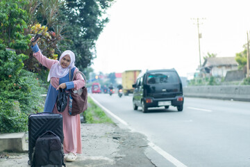 Obraz premium asian muslim women with suitcase prepare to go. concept of man and woman travelling for eid mubarak celebration