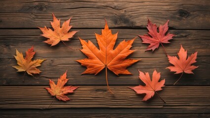 Fototapeta premium Autumn maple leaves arranged on rustic wooden background creating a warm seasonal aesthetic perfect for fall-themed designs.