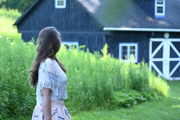 woman on the background of the landscape and a wooden house,