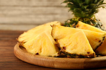 Cut fresh ripe pineapple on wooden table, closeup