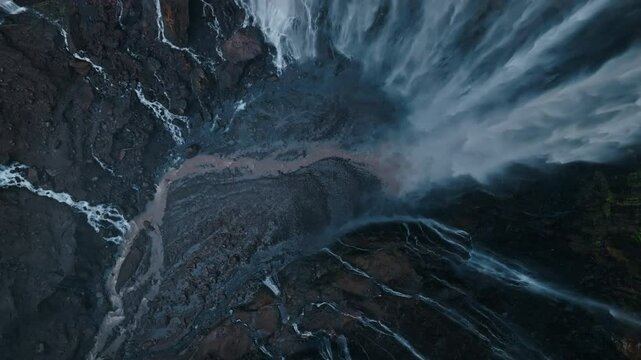 Aerial top view drone rise up and spin from bottom of Tumpak Sewu waterfall