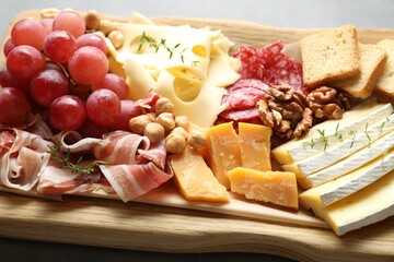 Different types of cut cheese and other snacks on table, closeup