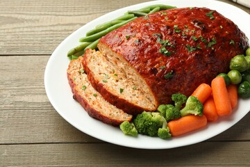 Delicious baked turkey meatloaf with vegetables on wooden table, closeup