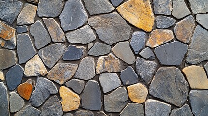 Fototapeta premium A textured surface of various stones in shades of gray and brown, arranged irregularly to create a natural, earthy look.