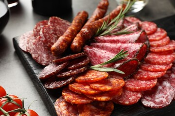 Different smoked sausages slices served on grey table, closeup