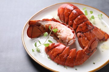 Delicious tails of boiled lobsters served on grey table, closeup