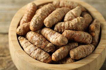 Tumeric rhizomes in bowl on table, closeup