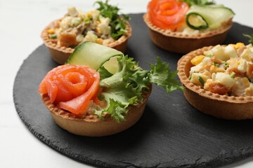 Tartlets with delicious fillings on white table, closeup