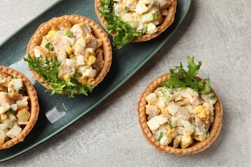 Tartlets with delicious filling on grey table, top view