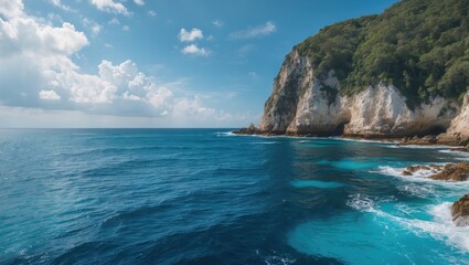 Obraz premium Serene Coastal View of Turquoise Ocean Water with Lush Green Cliffs Under Bright Blue Sky and Ample Copy Space for Text Elements