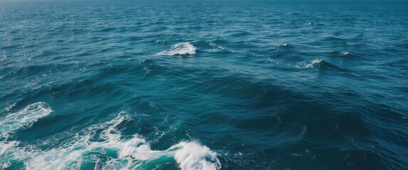 Obraz premium Vast Blue Ocean Waves with Tranquil Water Surface and Ample Copy Space for Textual Content or Graphics.
