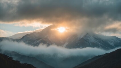 Majestic mountains under cloudy skies illuminated by sunlight with serene fog creating a tranquil atmosphere and empty space for text insertion.