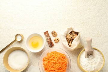 Different ingredients for making carrot cake on beige textured table, flat lay. Space for text