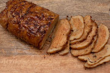 Seitan: vegan meat alternative made of washed flour gluten spices. Roasted and served on wooden board