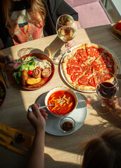 A friendly lunch with wine and Italian pizza in a sunny restaurant