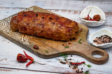 Seitan roast flavored with spices, glazed and served on wooden board