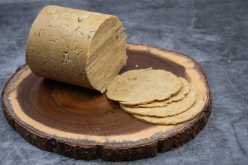 Vegan ham made in ham mold, sliced, wooden board. Mock vegan meat as plant based alternative to meat.