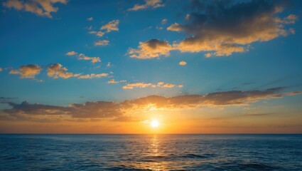 Obraz premium Beautiful sunset over calm ocean waters with vibrant sky and clouds illuminated by sunlight Copy Space