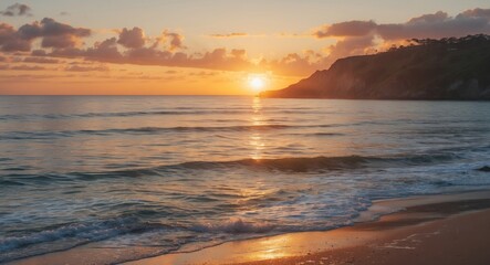 Fototapeta premium Coastal sunset over calm ocean waters with gentle waves and sandy beach in foreground illuminated by warm light