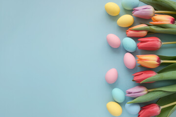 Easter background. Colorful spring tulips with butterflies and painted eggs
