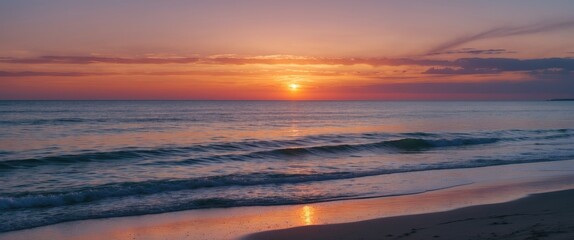 Sunset over calm ocean waves with reflection on sandy beach and colorful sky in the background Copy Space