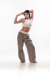 Obraz premium Young girl in trousers posing on a white background