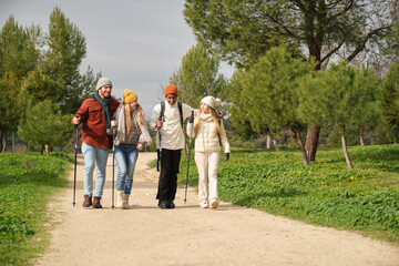 Friends enjoying nordic walking together in the park during wintertime