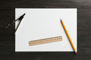 Ruler, paper, compass and pencil on black wooden table, flat lay. Space for text