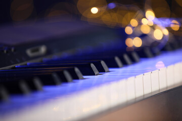 Piano against blurred lights, closeup. Bokeh effect