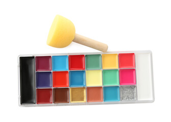 Bright face paint palette and sponge isolated on white, top view