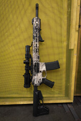 Naklejka premium Tactical rifle with optical sight in a shooting range. Vertical photo.