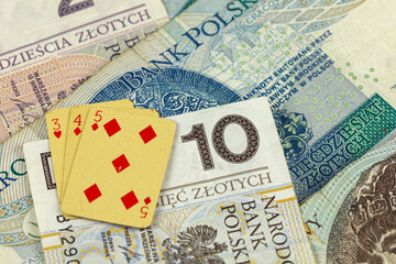 Fototapeta na wymiar A few banknotes of the Polish Zloty and some playing cards