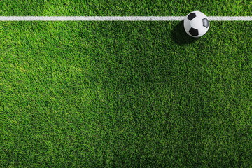 A soccer ball placed on the green turf, emphasizing the calm before the action begins on the lively soccer field.

