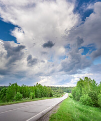 Road with trees in the background and a cloudy sky