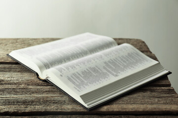 Open Holy Bible in English language on wooden table