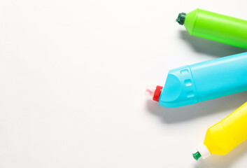 Bottles of different cleaning products on white background, flat lay. Space for text