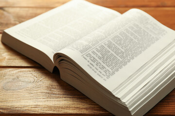 Open Holy Bible in English language on wooden table, closeup