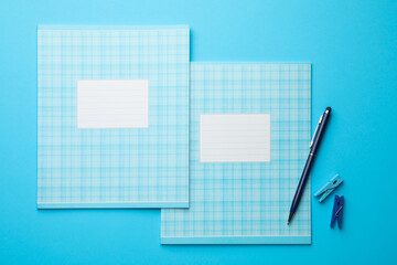 Flat lay composition with copybooks and pen on light blue background