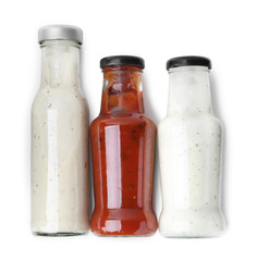 Different delicious sauces in glass bottles isolated on white, top view