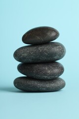 Stack of rocks on light blue background. Harmony and life balance