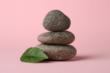 Stack of rocks on light pink background. Harmony and life balance