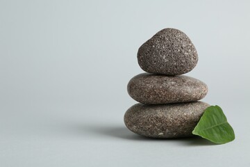Stack of rocks on light grey background, space for text. Harmony and life balance