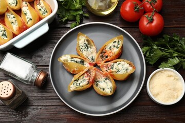 Delicious shell pasta stuffed with ricotta and spinach served on wooden table, flat lay