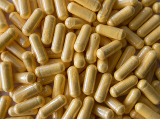 Yellow tablets or pills on the black stone background.