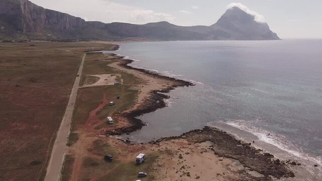 Aerial drone view of Macari (Makari), Sicily. Crystal clear turquoise waters, rugged cliffs, golden sandy beaches. A serene natural landscape with Mediterranean charm near San Vito lo Capo.	