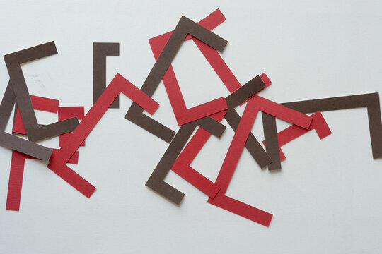 overlapping machine-cut geometric shapes in red and brown on blank paper